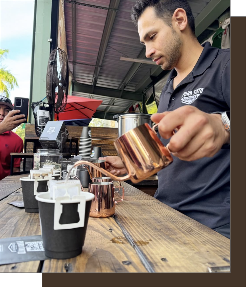Barista preparing Puro Tinto Drip Coffee with precision, pouring water into a filter at yellow green farmers market