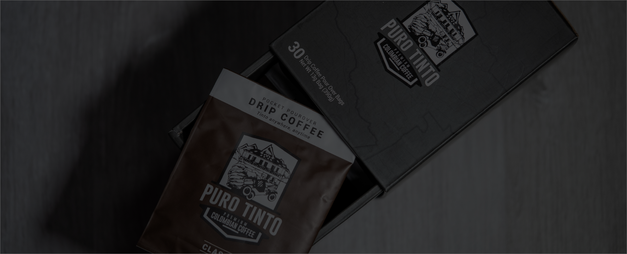 Puro Tinto Colombian Drip Coffee multi-pack box with a single classic drip coffee pouch emerging from it